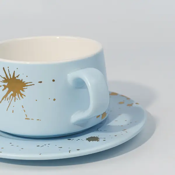 Detalhe do cabo cerâmico da caneca de café com decoração com respingos de folha de ouro
