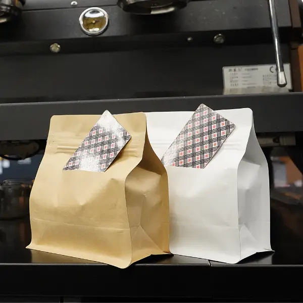 Saquinhos de café horizontais com fenda para cartão exibidos em ambiente de cafeteria