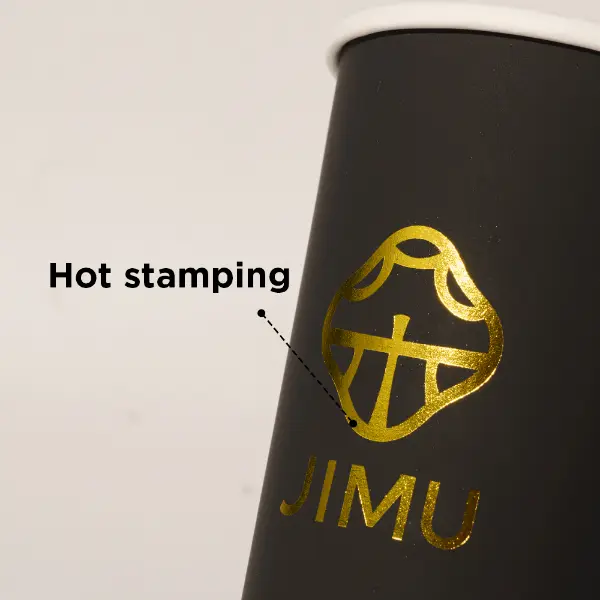 Detalhe de estampagem quente em folha de ouro no copo de papel preto premium