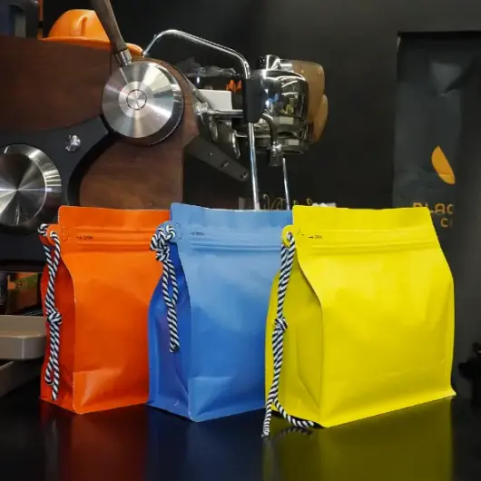 Saquinhos de café personalizados com cordão não são mais um formato de nicho em 2026. Eles se tornaram um prático, Escolha de embalagem de alto volume para grãos a granel e café moído — especialmente quando as marcas precisam tanto de força operacional quanto de uma limpeza, Look pronto para o varejo. At YPAK, Tratamos o cordão como mais do que uma tira. Usado corretamente, ele se torna um ponto de manuseio funcional e um sinal visual de durabilidade, O que pode influenciar como os compradores avaliam a qualidade em poucos segundos. Embalagens em grande quantidade têm um desafio constante: Deve trabalhar duro no fundo do espaço, mas ainda assim representam a marca na frente do palco. Isso significa estabilidade, Refechamento confiável, Gestão de gás, e conveniência de manuseio. Quando esses elementos se juntam, A sacola deixa de ser 